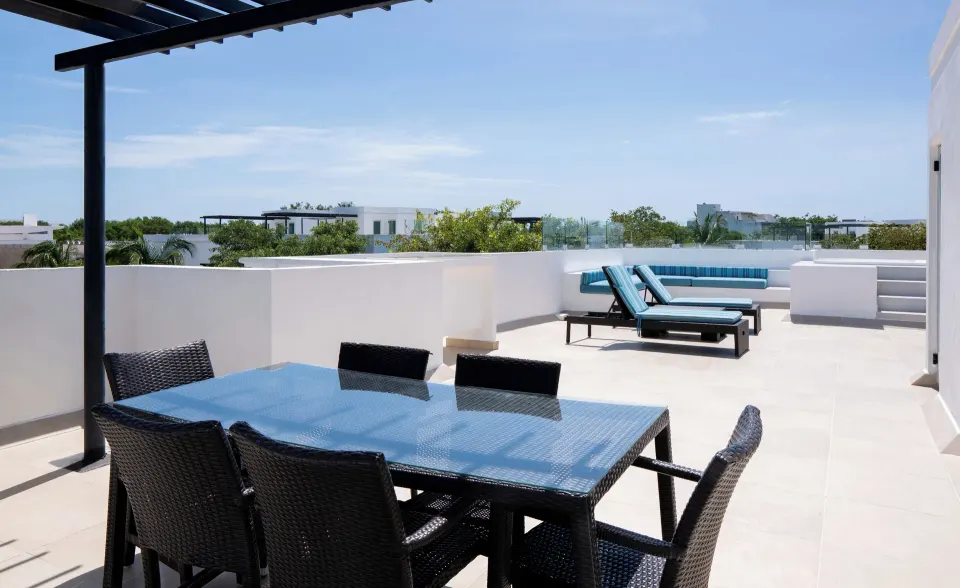 One Bedroom Penthouse Suite rooftop dining table and loungers at The Fives Beach Hotel.