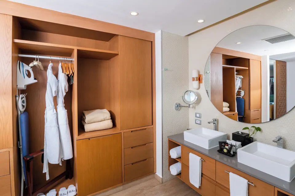 One Bedroom Suite bathroom with open wardrobe and double vanity at The Fives Beach Hotel.