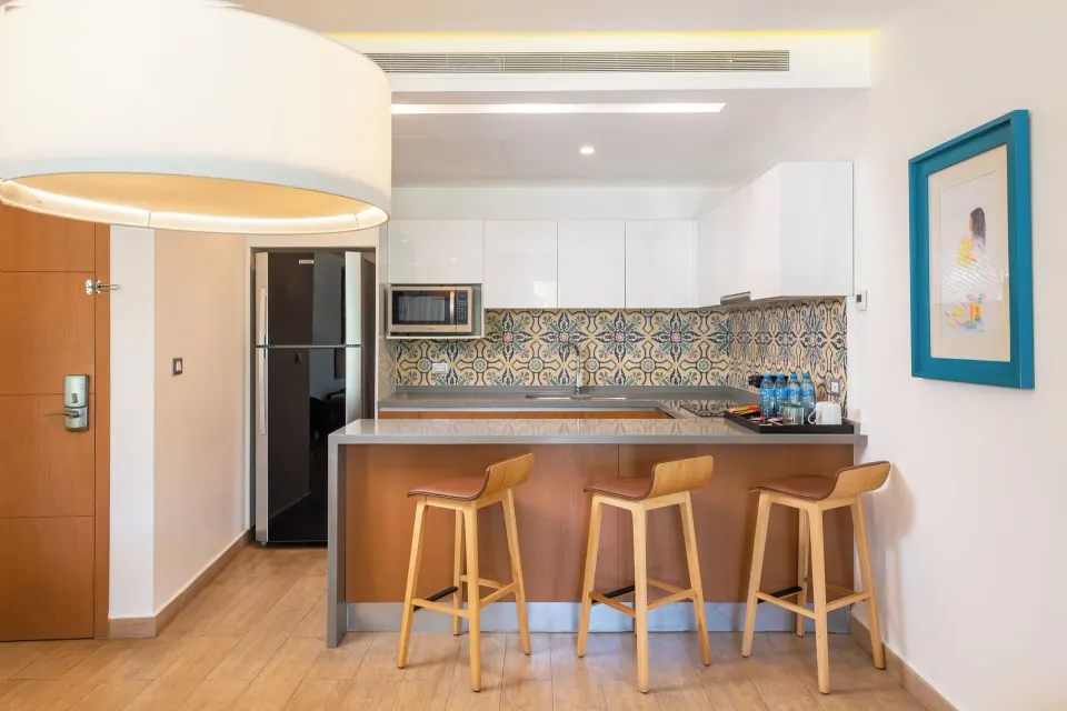 One Bedroom Suite kitchenette with bar stools at The Fives Beach Hotel.