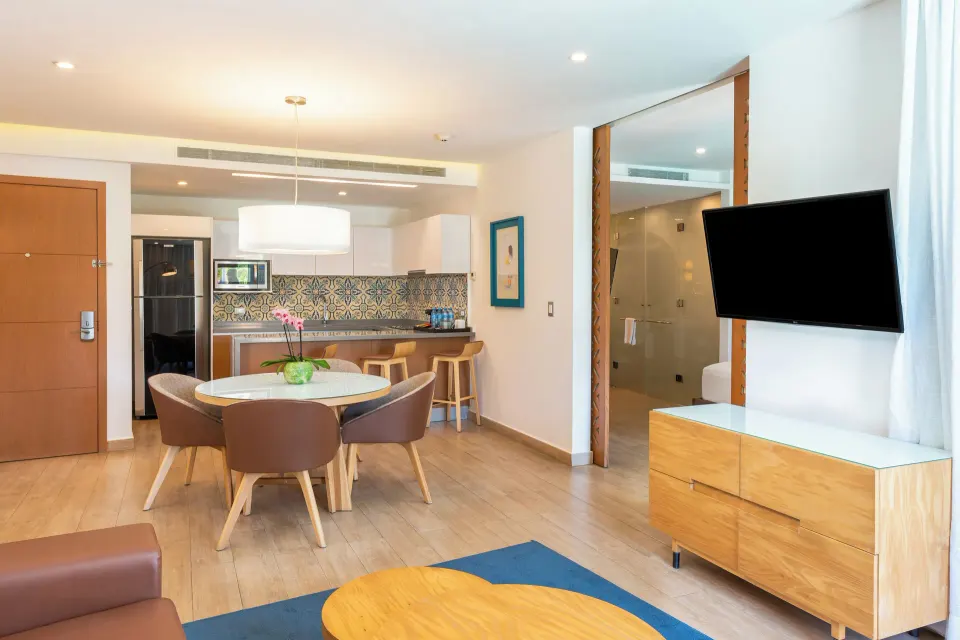 One Bedroom Suite living and dining area with kitchenette at The Fives Beach Hotel.