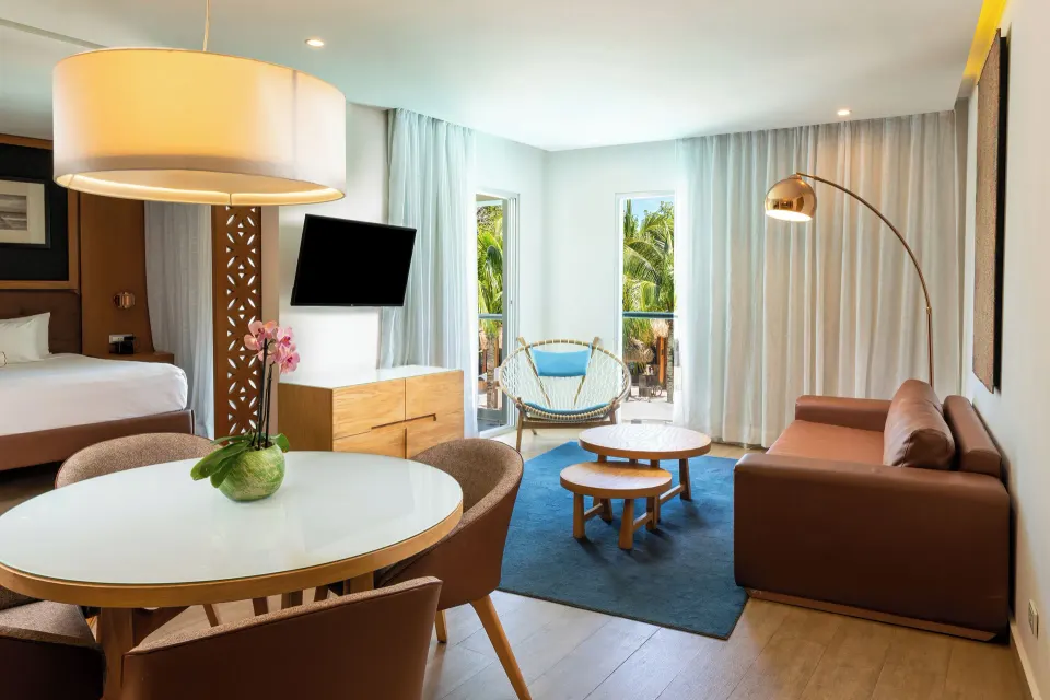 One Bedroom Suite living room with sofa and balcony windows at The Fives Beach Hotel.