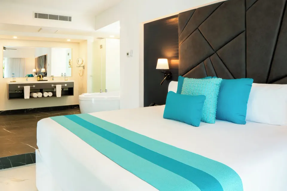 Three Bedroom Suite king bedroom with open bathroom and tub at The Fives Beach Hotel.