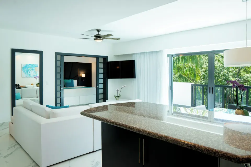 Three Bedroom Suite living area with balcony and kitchenette at The Fives Beach Hotel.