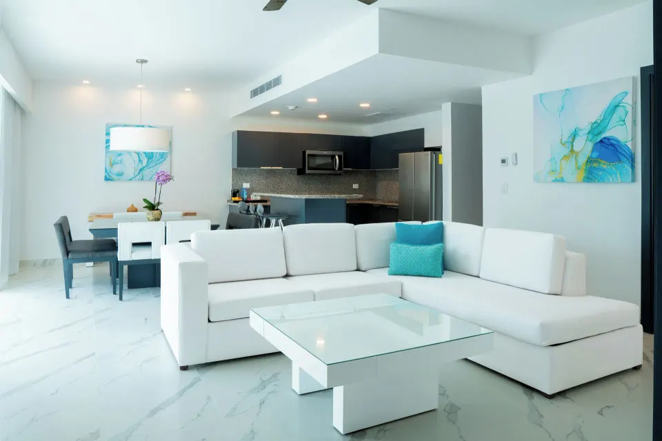 Three Bedroom Suite living room with sofa, dining table and kitchen at The Fives Beach Hotel.