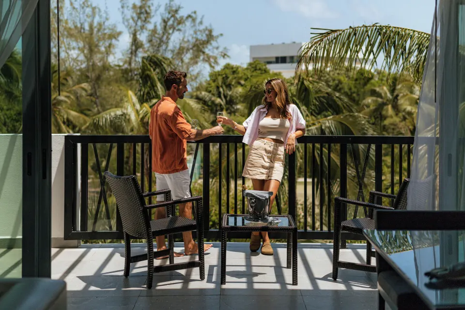 Two Bedroom Suite balcony with two guests and outdoor seating at The Fives Beach Hotel.