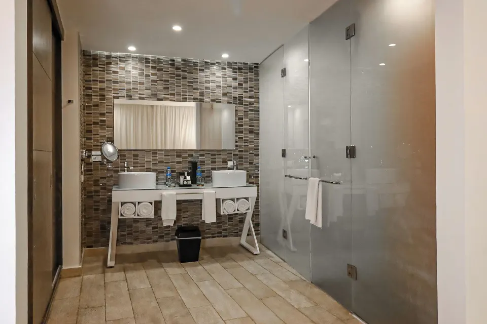 Two Bedroom Suite bathroom with double sinks and glass shower at The Fives Beach Hotel.