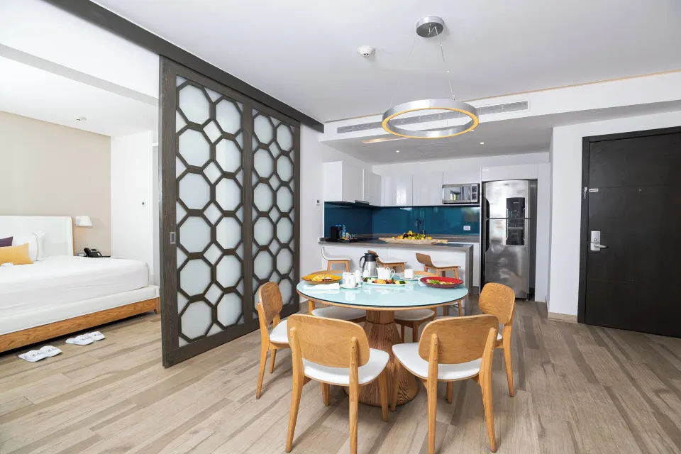 Two Bedroom Suite dining area, kitchen, and bedroom entrance at The Fives Beach Hotel.