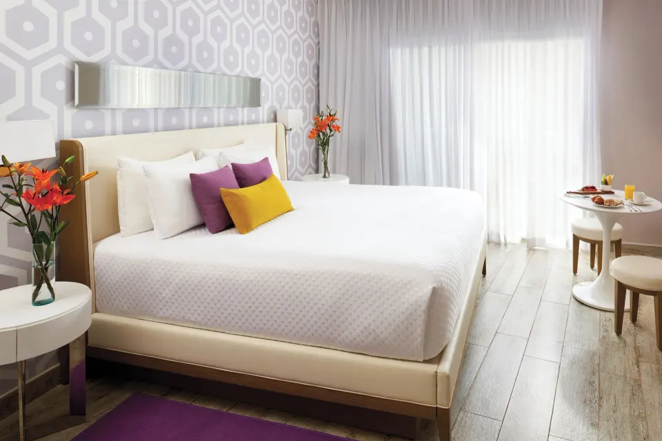 Two Bedroom Suite king bedroom with breakfast table at The Fives Beach Hotel.