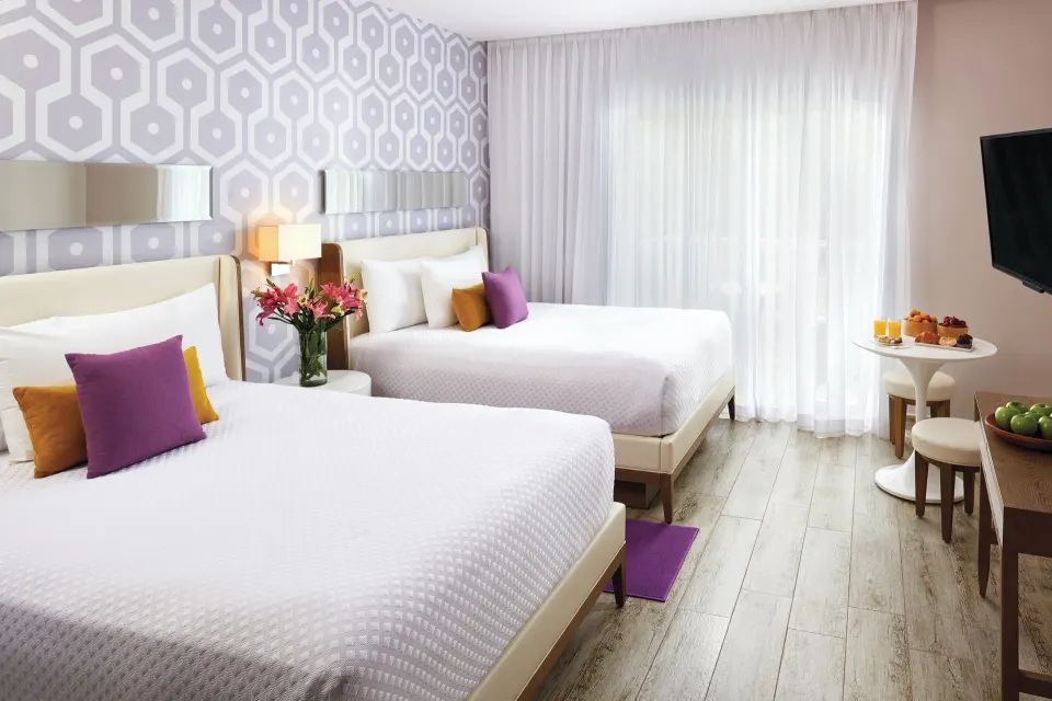 Two Bedroom Suite bedroom with two double beds and TV at The Fives Beach Hotel.