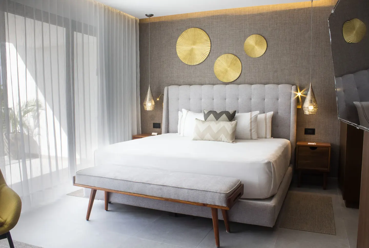 King bed with gold wall decor at The Fives Oceanfront Riviera Maya.