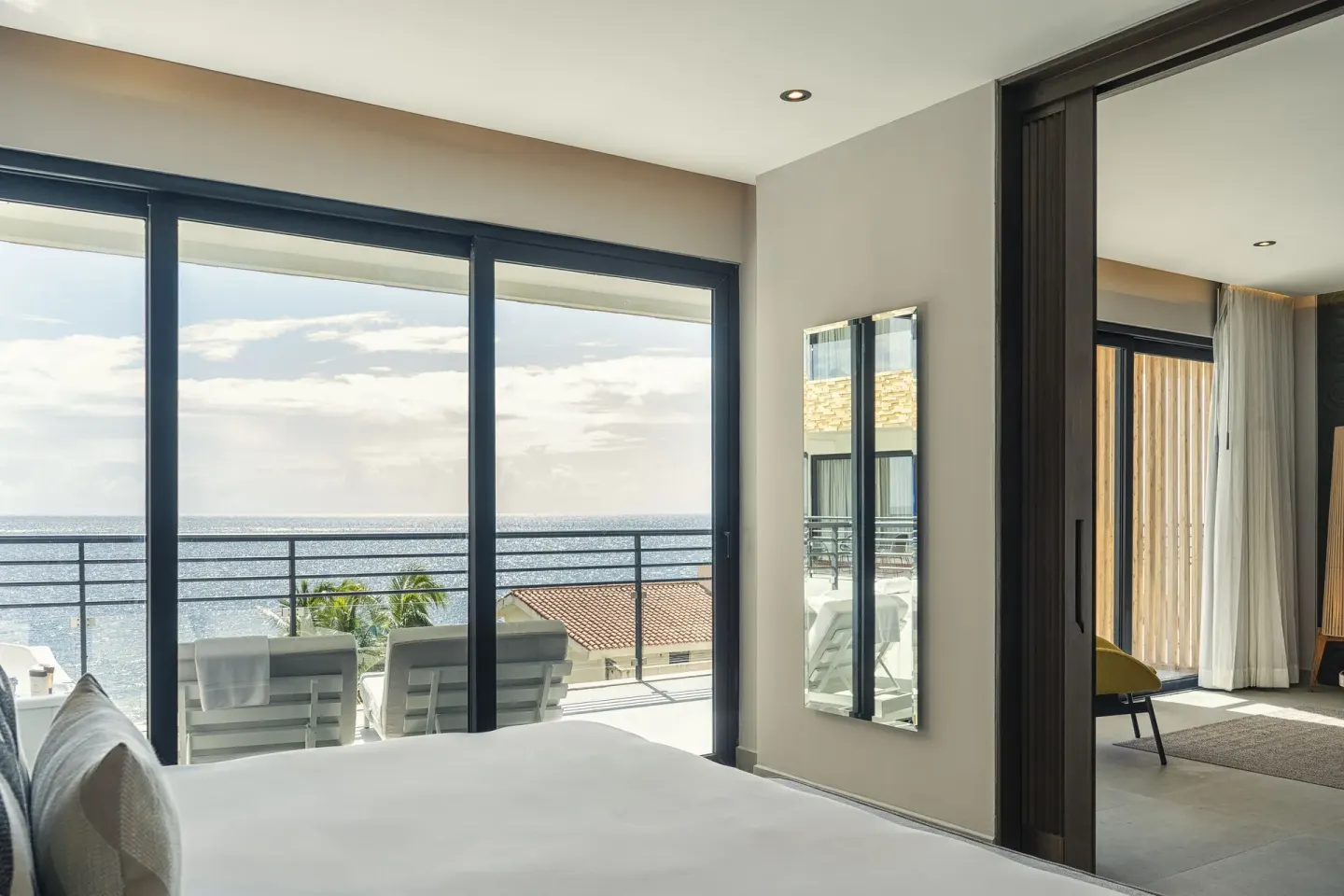 Ocean-view bedroom with balcony loungers at The Fives Oceanfront Riviera Maya.