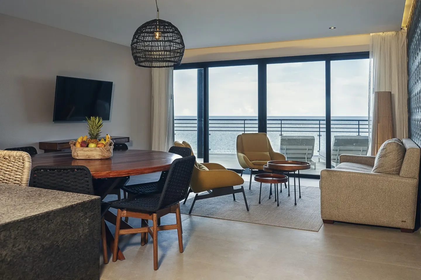 Ocean-view suite living room and dining table at The Fives Oceanfront Riviera Maya.