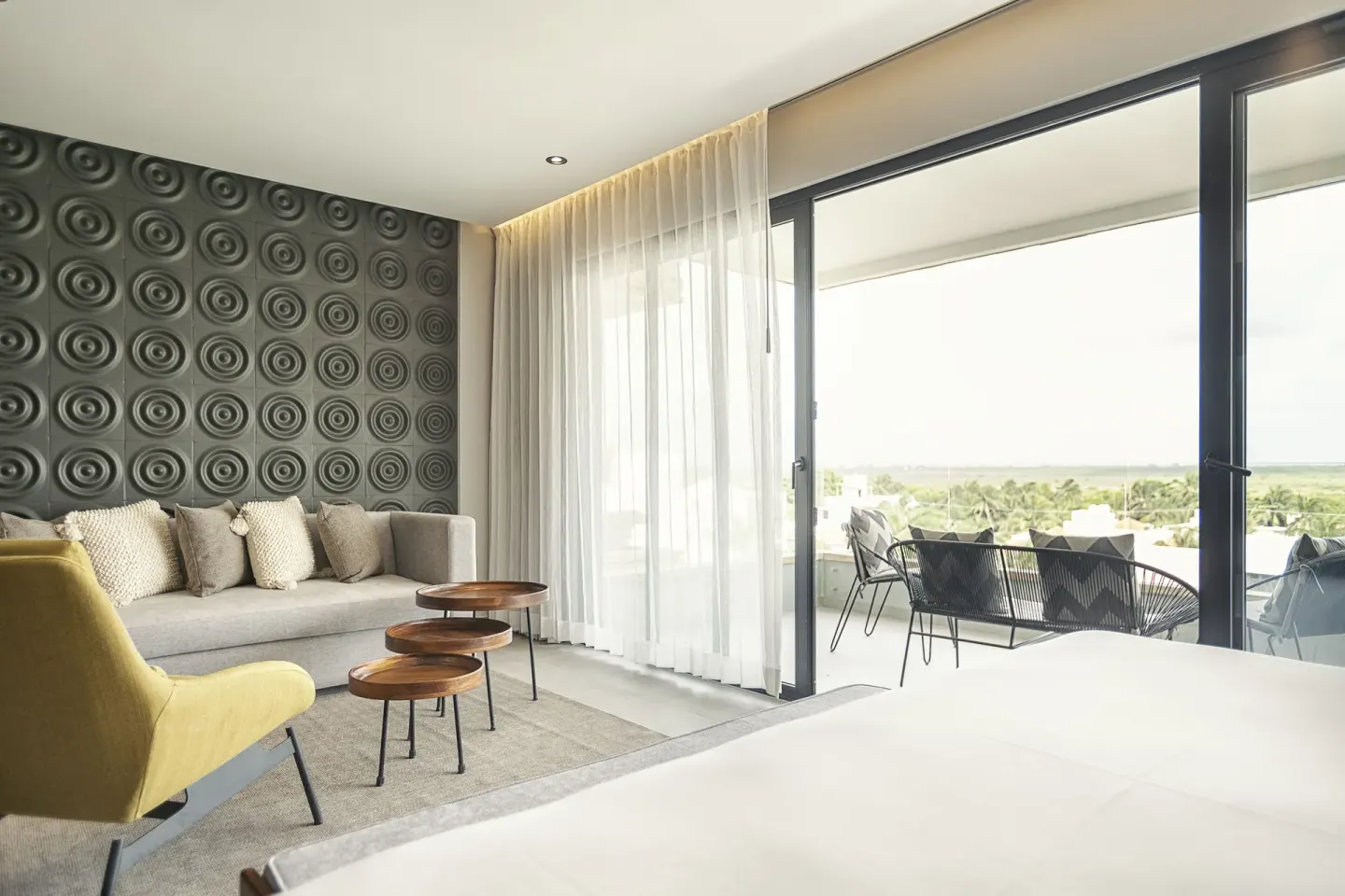 Suite bedroom and lounge with balcony view at The Fives Oceanfront Riviera Maya.
