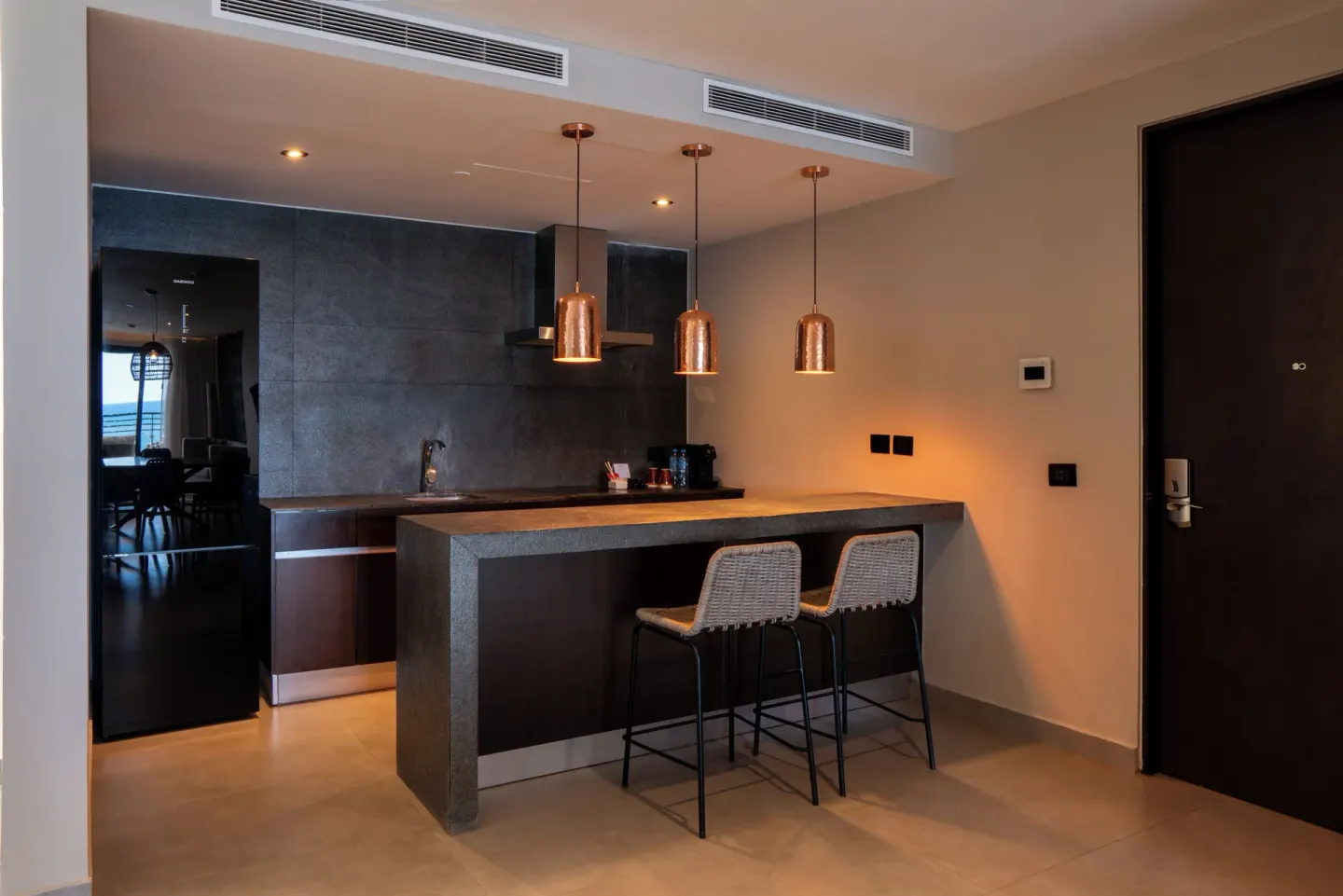 Suite entry kitchenette with bar seating at The Fives Oceanfront Riviera Maya.