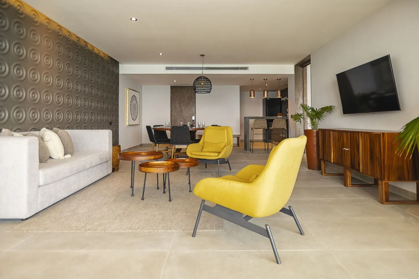 Suite living and dining area with yellow chairs at The Fives Oceanfront Riviera Maya.