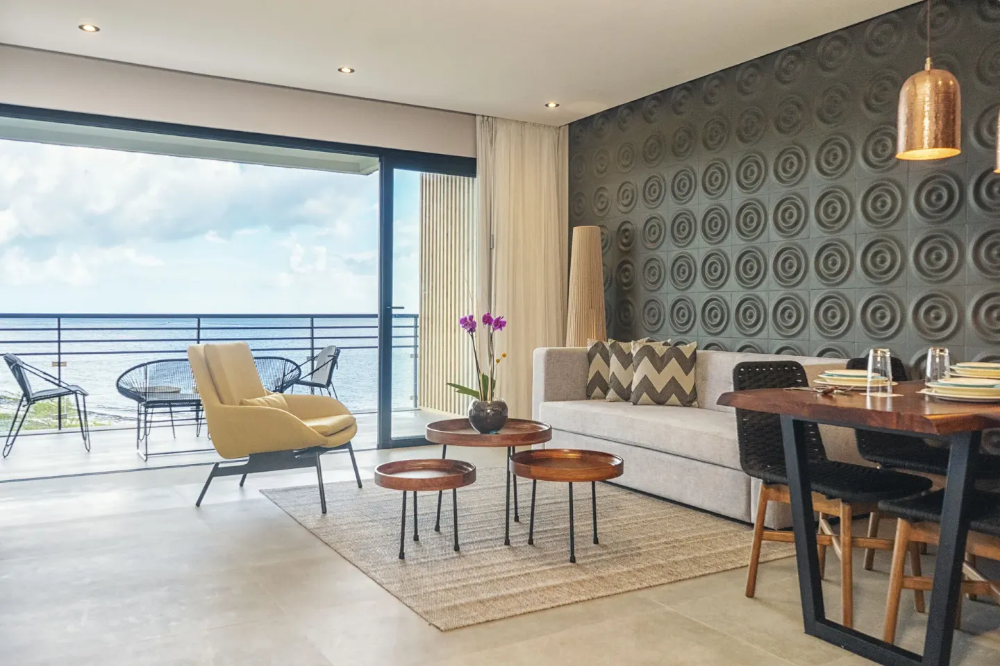 Suite living area with balcony seating and ocean view at The Fives Oceanfront Riviera Maya.