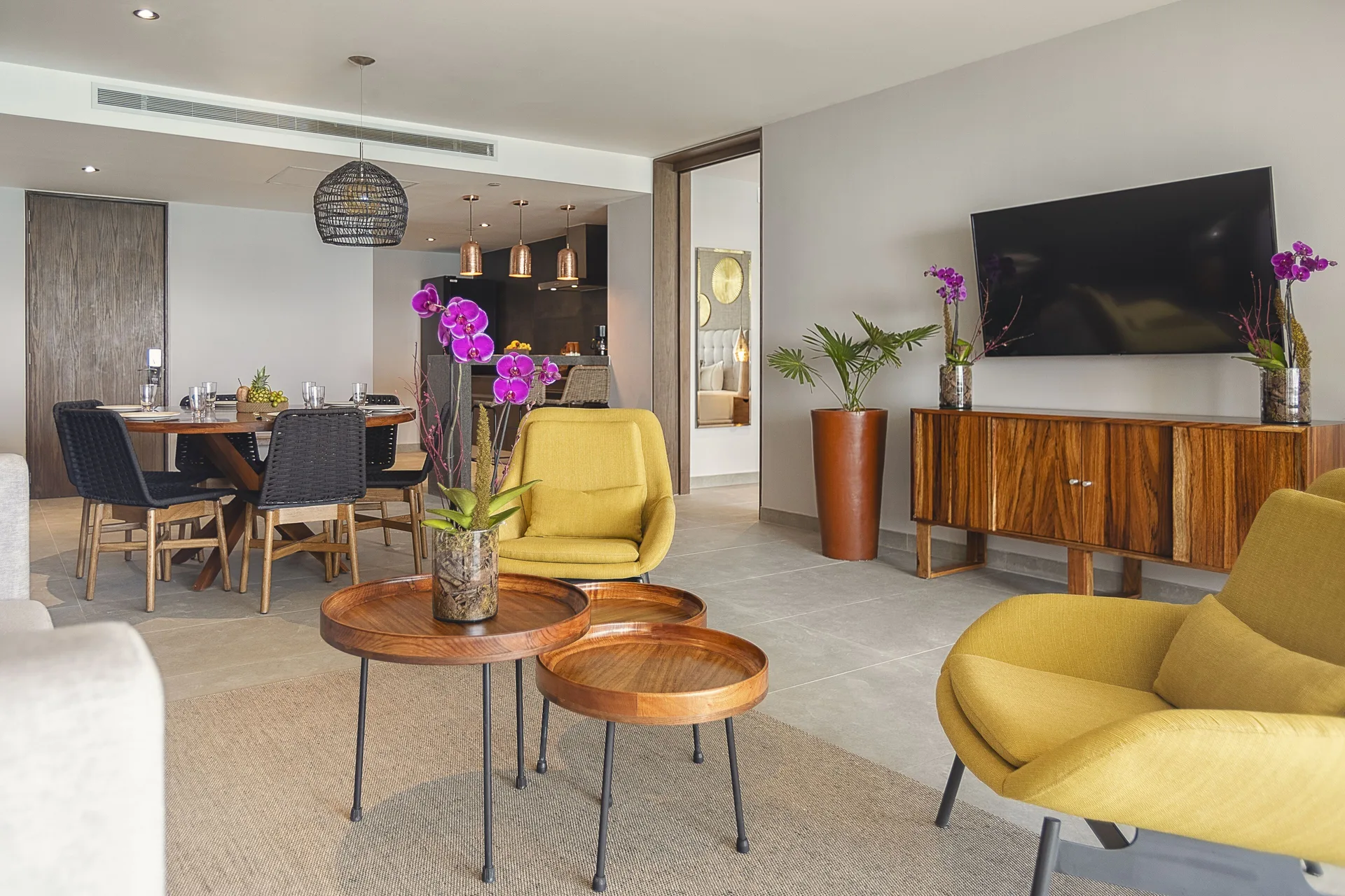 Suite living room with dining area and TV at The Fives Oceanfront Riviera Maya.