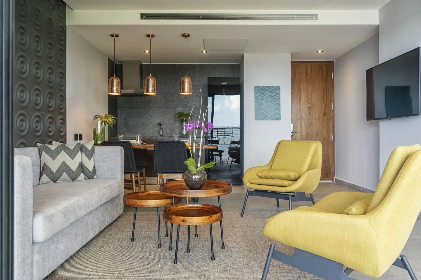 Suite lounge with kitchenette and TV at The Fives Oceanfront Riviera Maya.