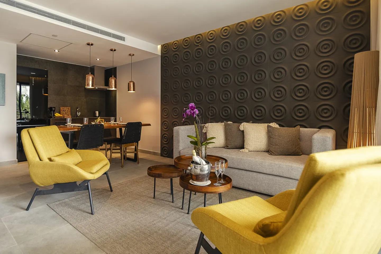 Suite lounge with patterned wall and sofa at The Fives Oceanfront Riviera Maya.