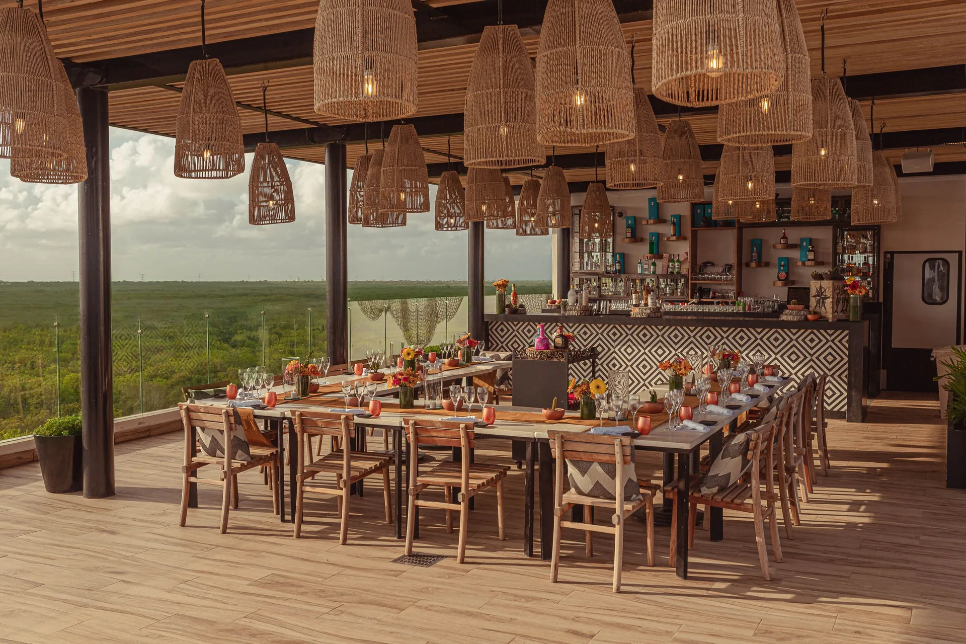Rooftop dining area with woven pendant lights at The Fives Oceanfront Riviera Maya.