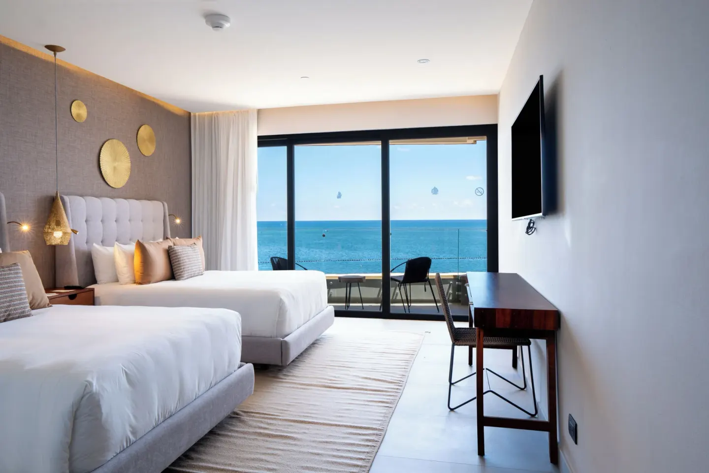 Oceanfront bedroom with two beds and balcony at The Fives Oceanfront Riviera Maya.