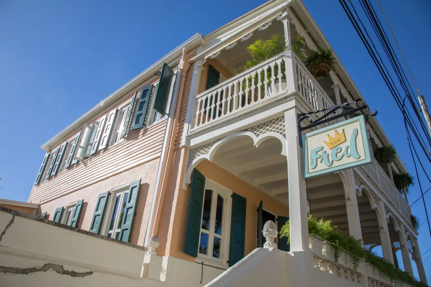 Low-angle view of the pink exterior, balconies, and sign at The Fred.