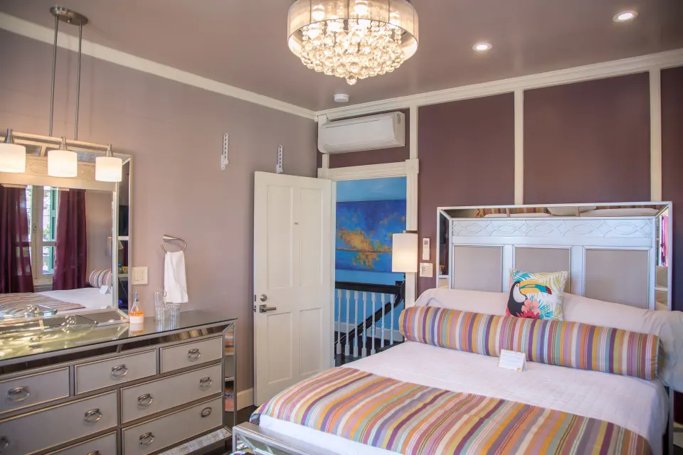 Basic Room Hill View Corner king bed and dresser beside an open door at The Fred.
