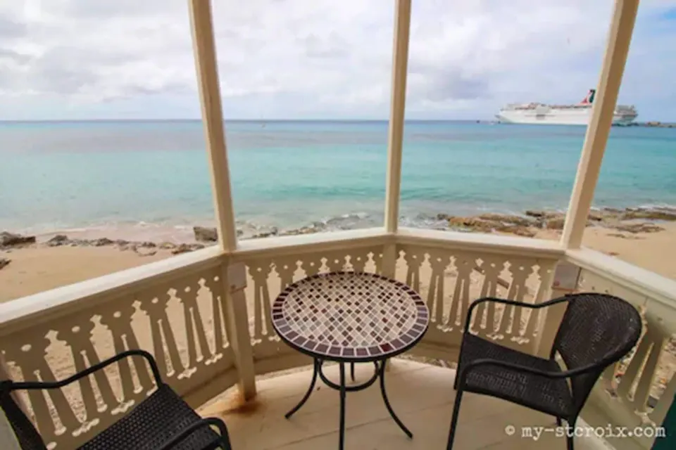 Honeymoon Room balcony seating facing the sea and sandy shore at The Fred.