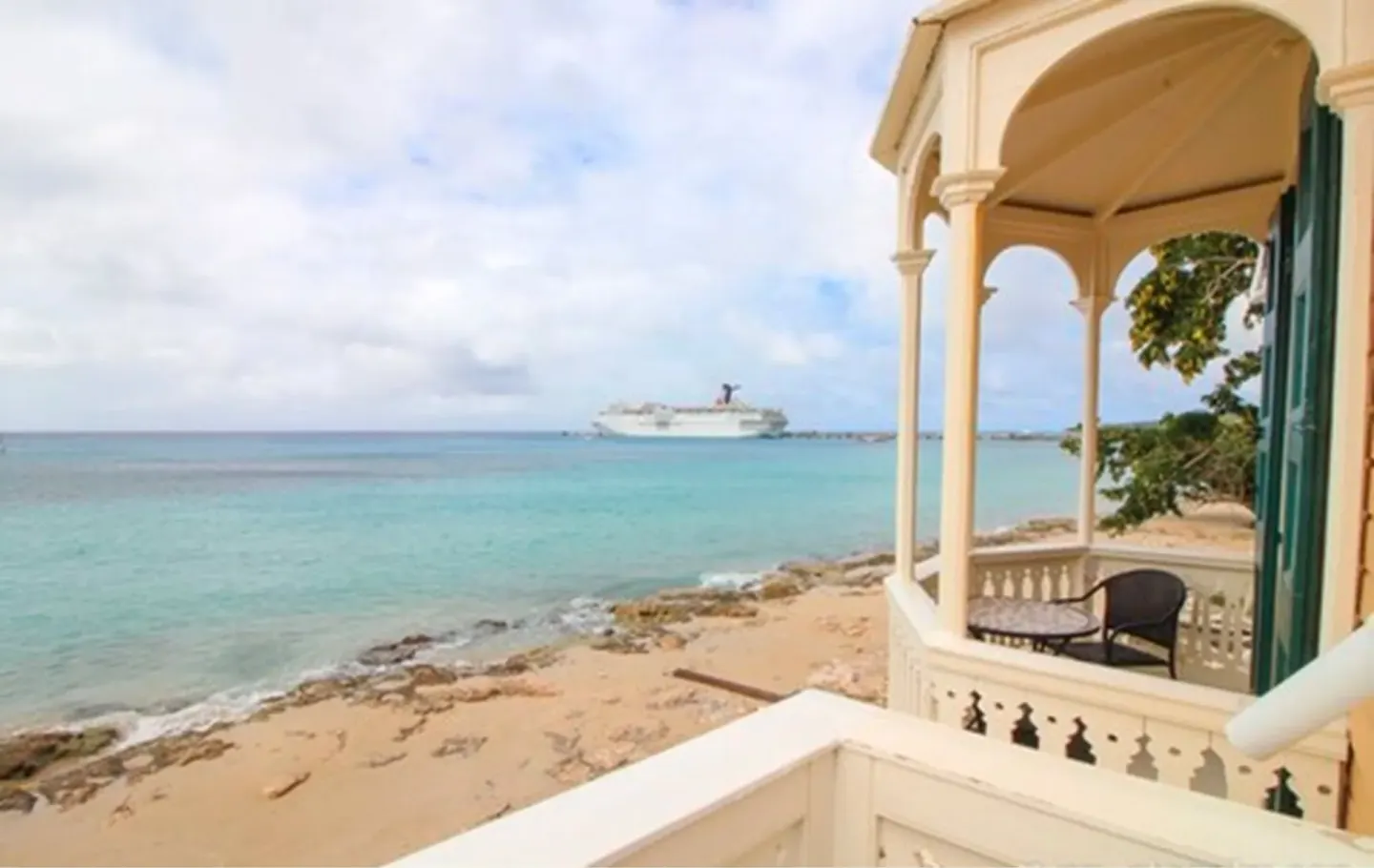 Rachel balcony at The Fred overlooking turquoise water and a sandy shoreline.