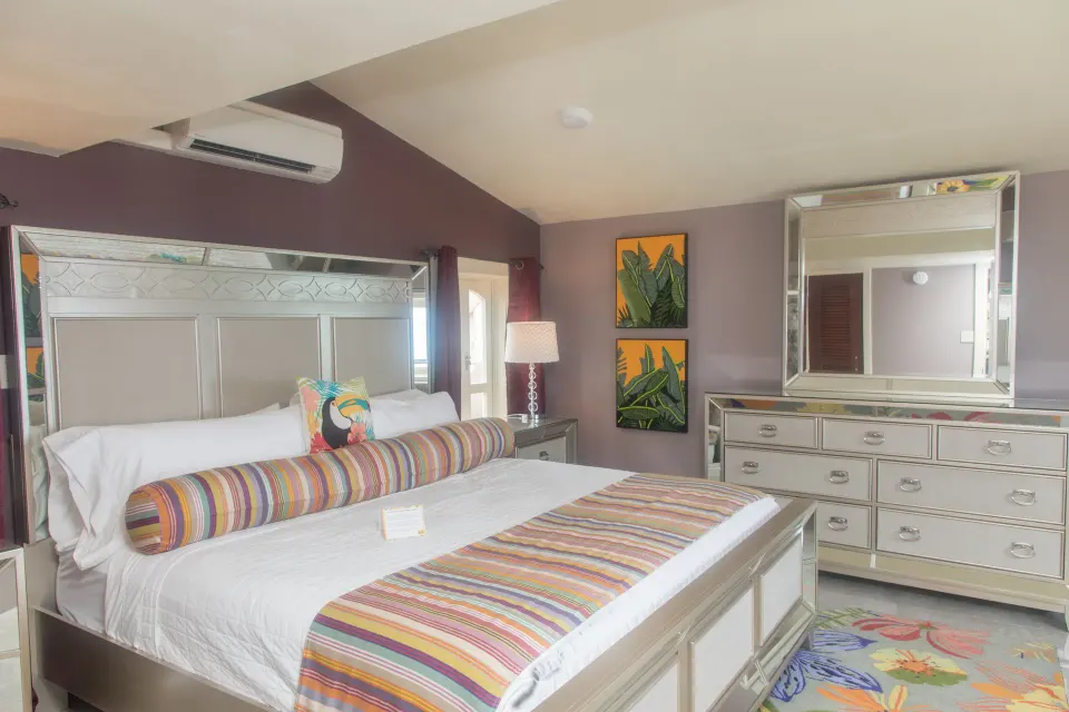 Honeymoon Suite bedroom with king bed, mirrored furniture, and striped linens at The Fred.