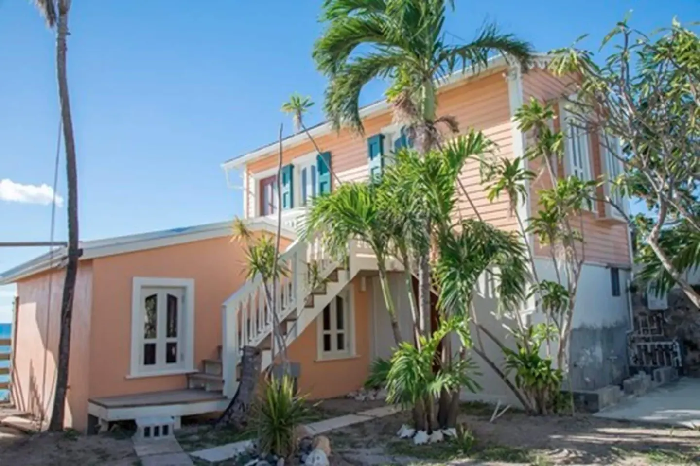 Exterior of the Honeymoon Suite building with palms and stairs at The Fred.