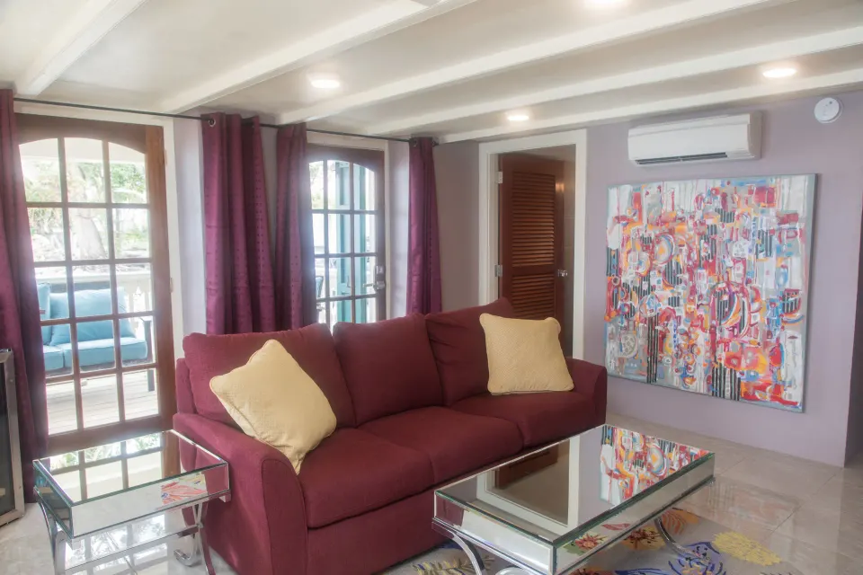 Honeymoon Suite sitting area with burgundy sofa and terrace doors at The Fred.