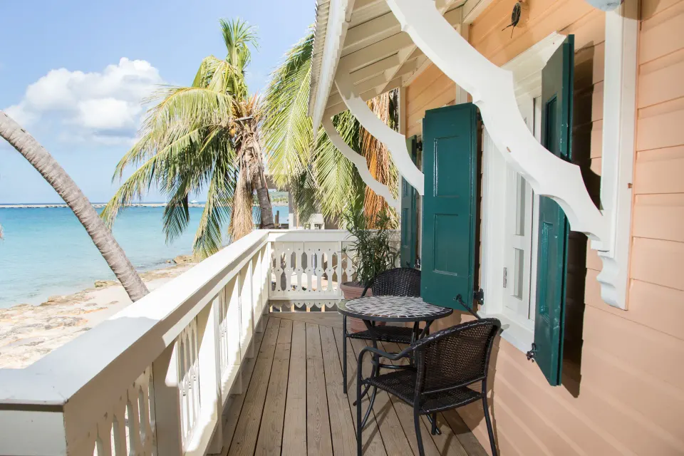 Sea-view balcony with table and chairs outside the Panoramic Room at The Fred.