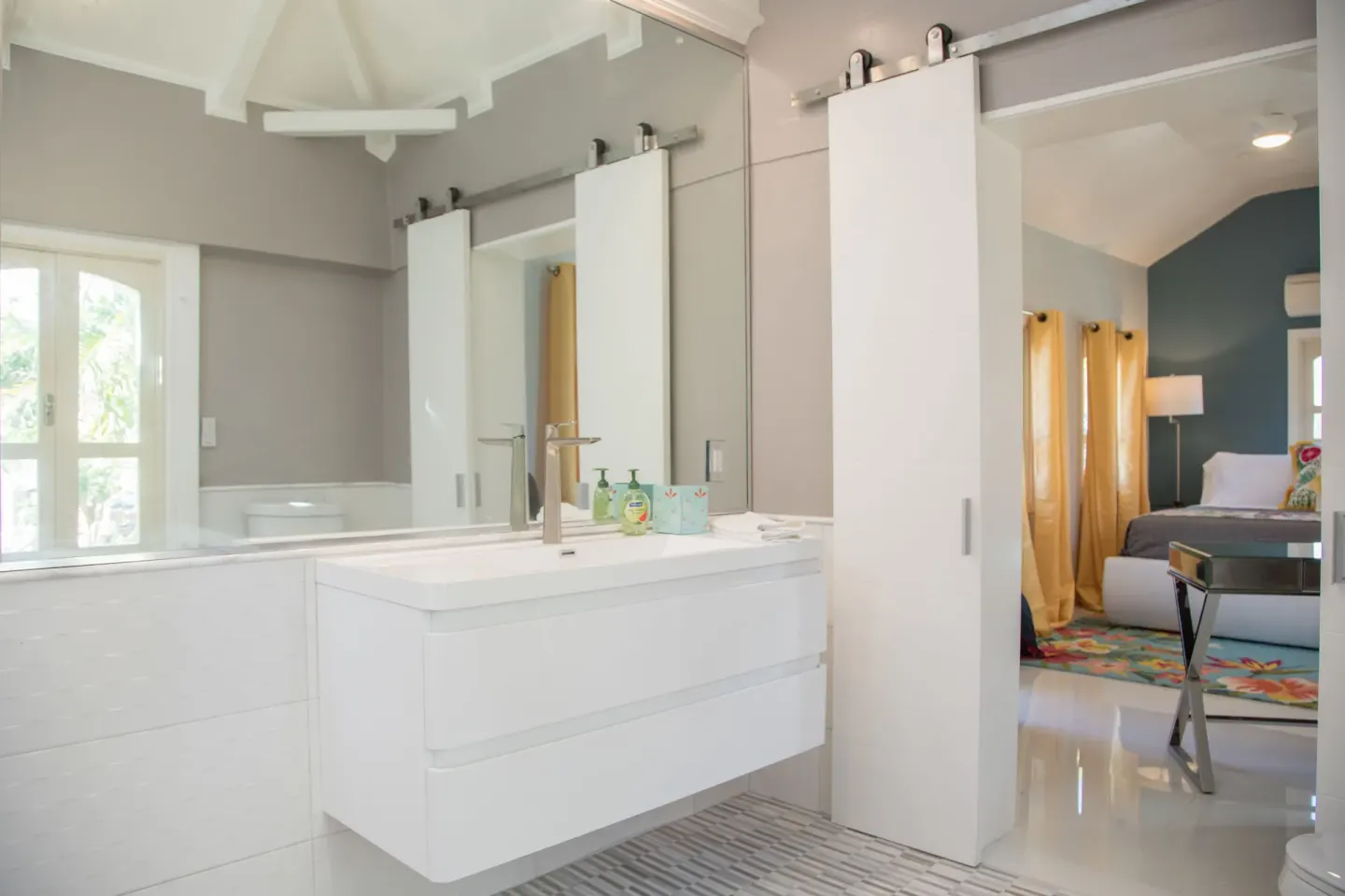 White bathroom vanity beside the Panoramic Room bedroom at The Fred.