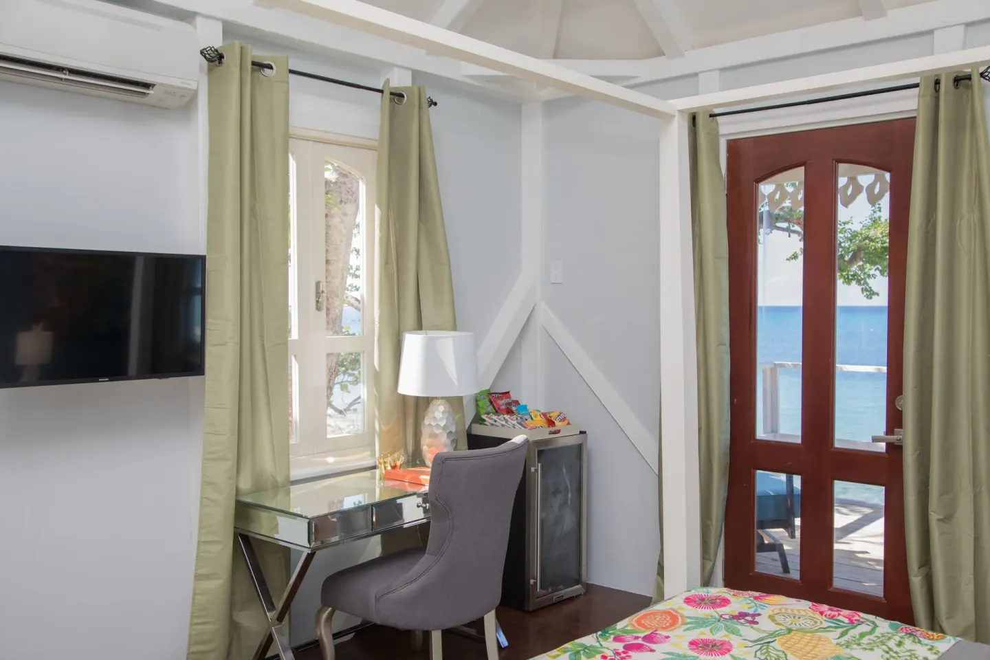 Premier Room Sea View at The Fred with desk, TV, bed corner, and ocean-facing door.