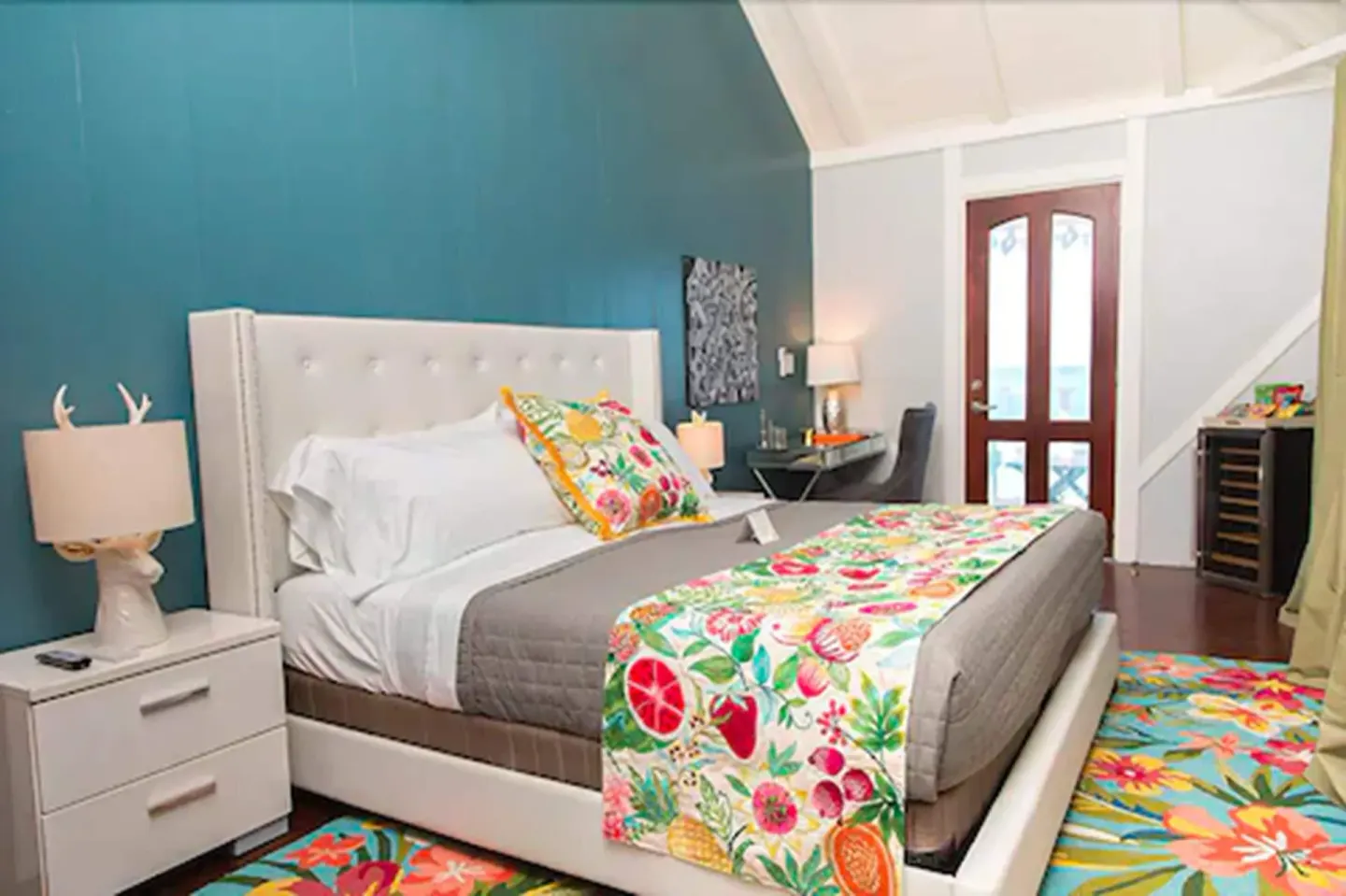 Premier Room Sea View at The Fred with tufted bed, teal wall, floral textiles, and ocean door.