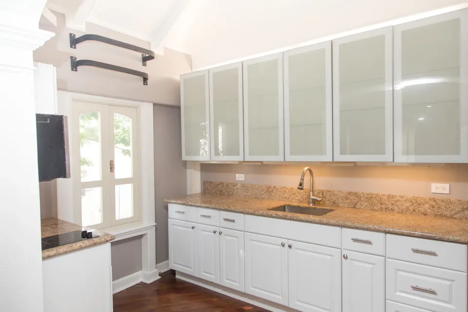 Kitchenette with white cabinets and a sink in a Premium room at The Fred.