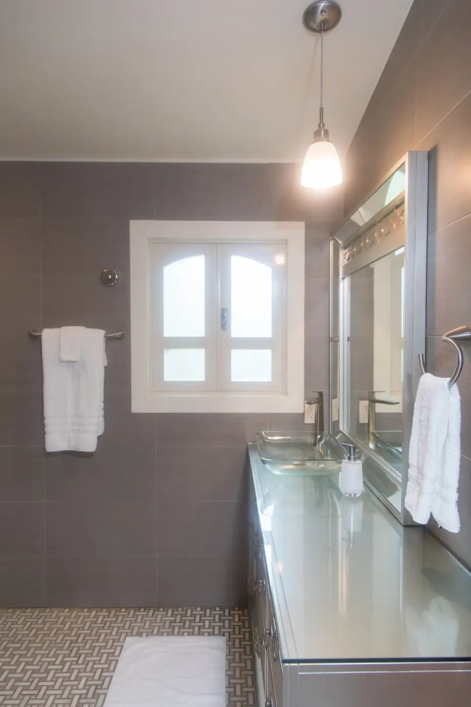 Premium studio suite bathroom with glass sink and mirrored vanity at The Fred.