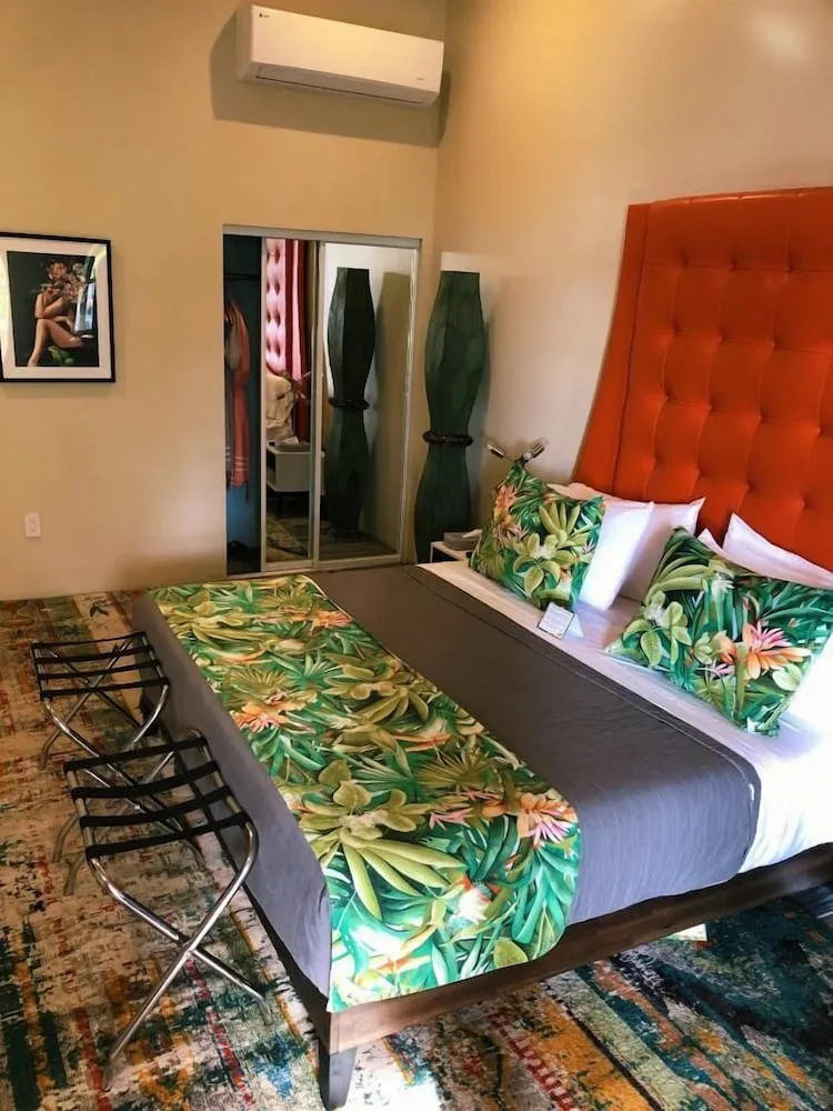 Standard Room Winchester bed, mirrored closet, and tropical decor at The Fred.
