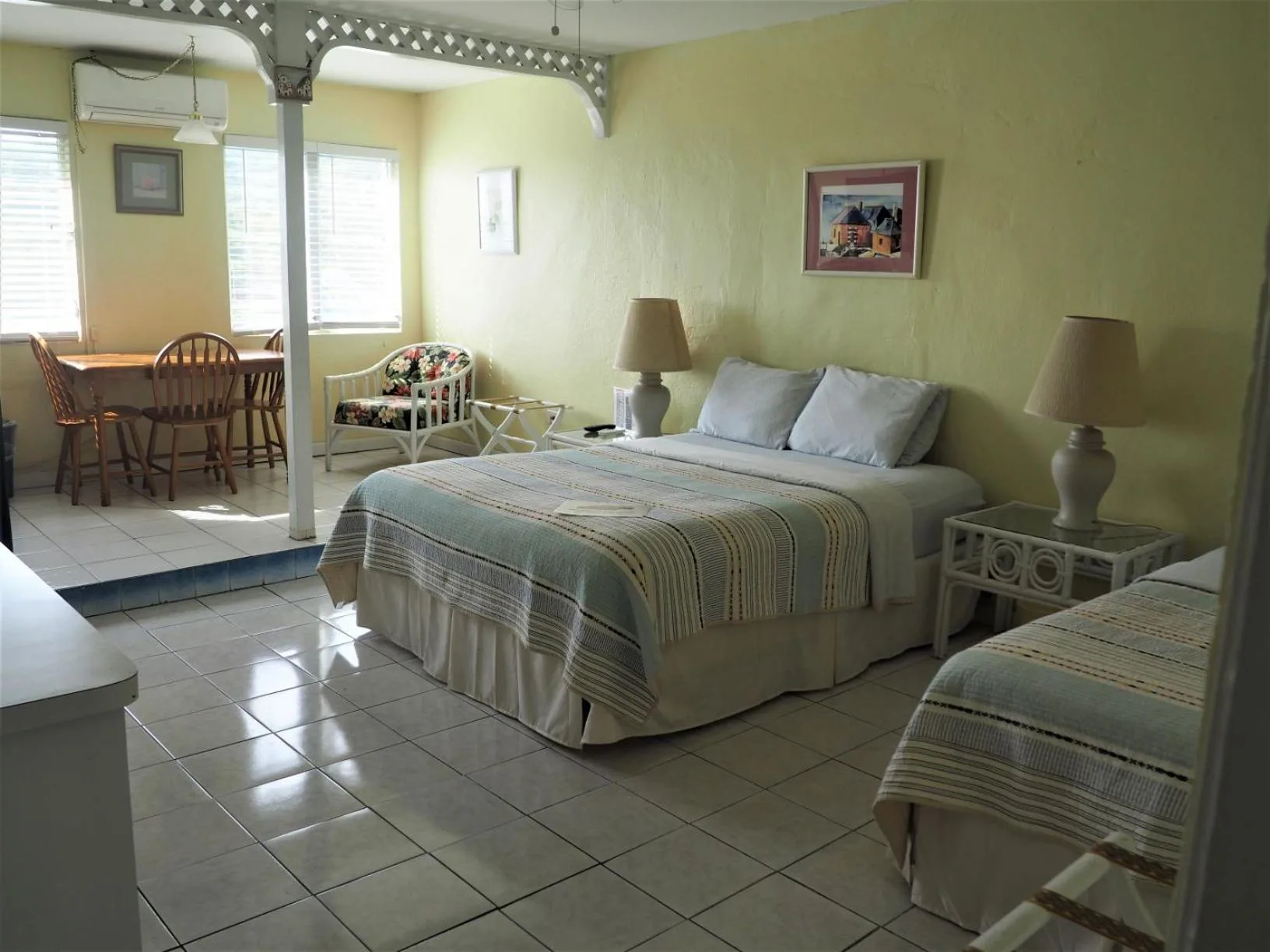 Guest room with two beds and a dining nook at The Green Iguana Hotel.