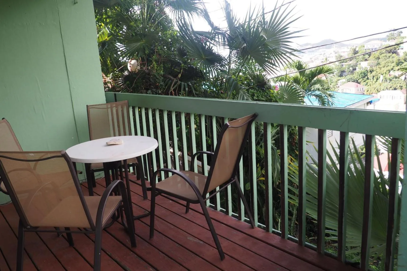 Private balcony with chairs and tropical greenery at The Green Iguana Hotel.