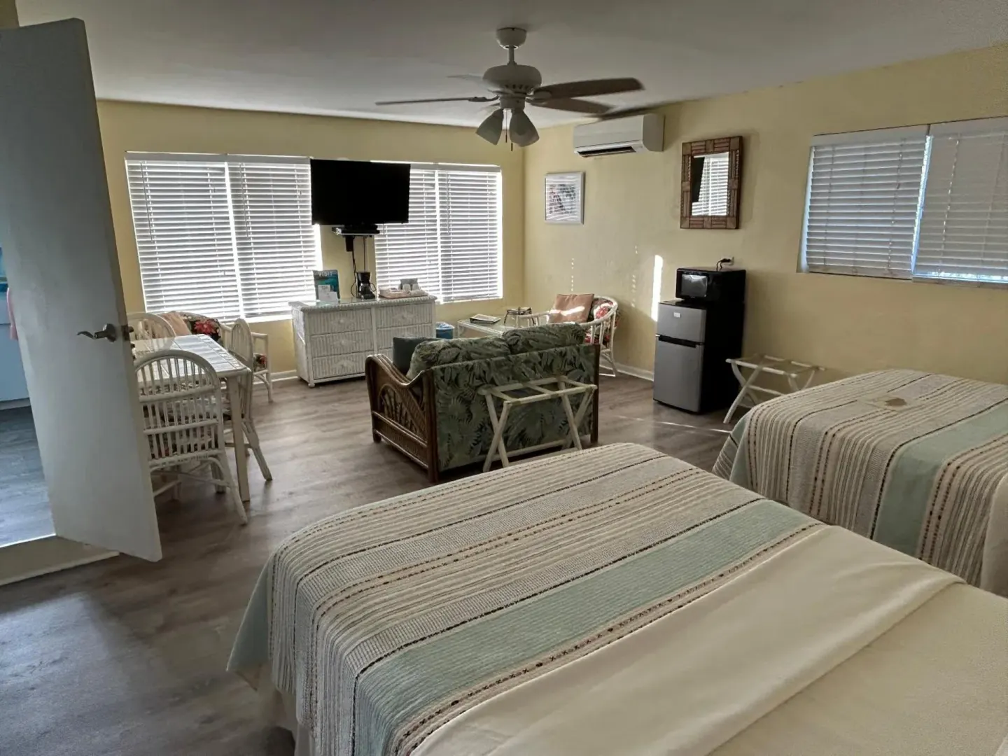 Studio-style guest room with two beds and sitting area at The Green Iguana Hotel.