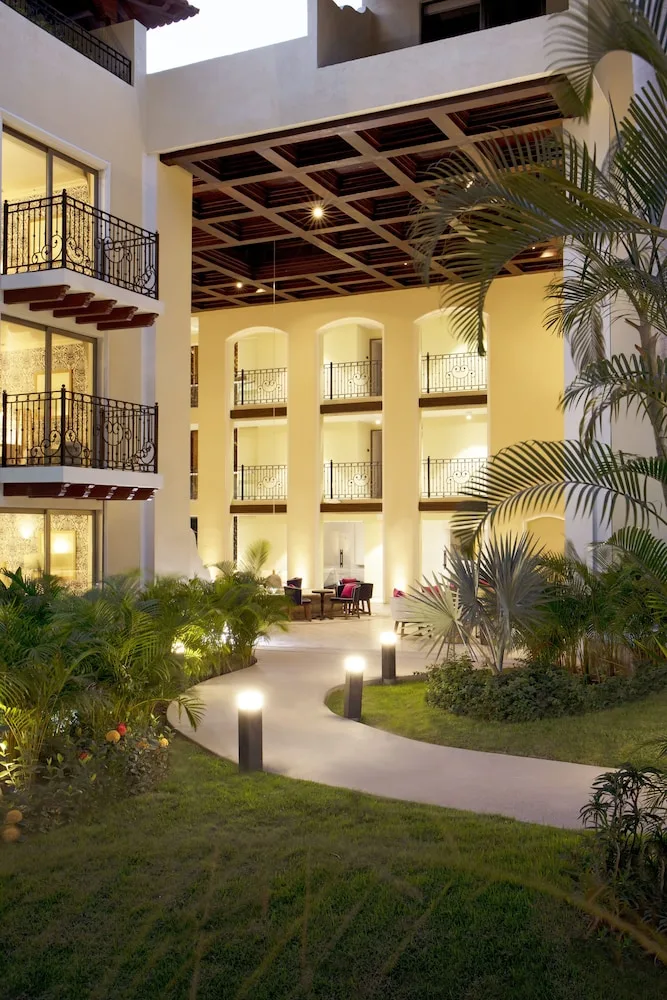 Illuminated courtyard balconies and garden paths at The Hacienda at Krystal Grand Puerto Vallarta.
