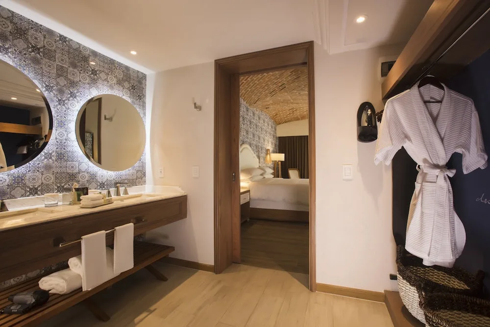 Bathroom vanity and robe beside guest room at The Hacienda at Krystal Grand Puerto Vallarta.