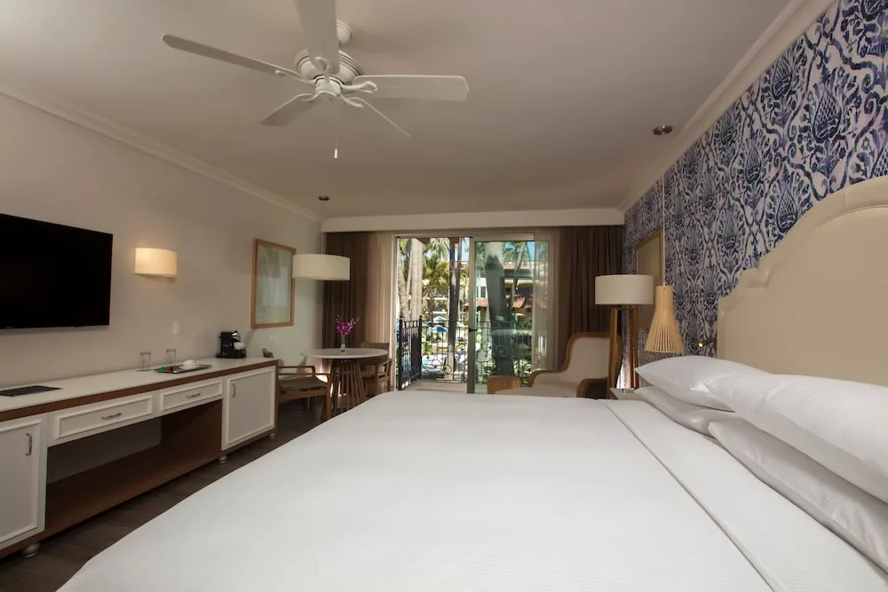 King guest room with balcony doors at The Hacienda at Krystal Grand Puerto Vallarta.