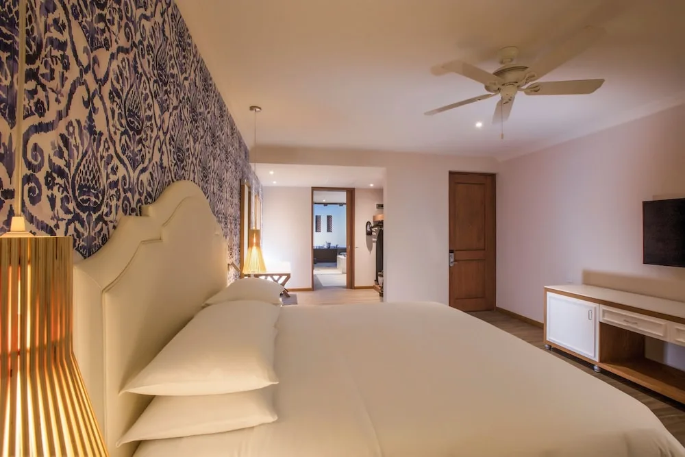 Guest room with king bed and patterned wall at The Hacienda at Krystal Grand Puerto Vallarta.
