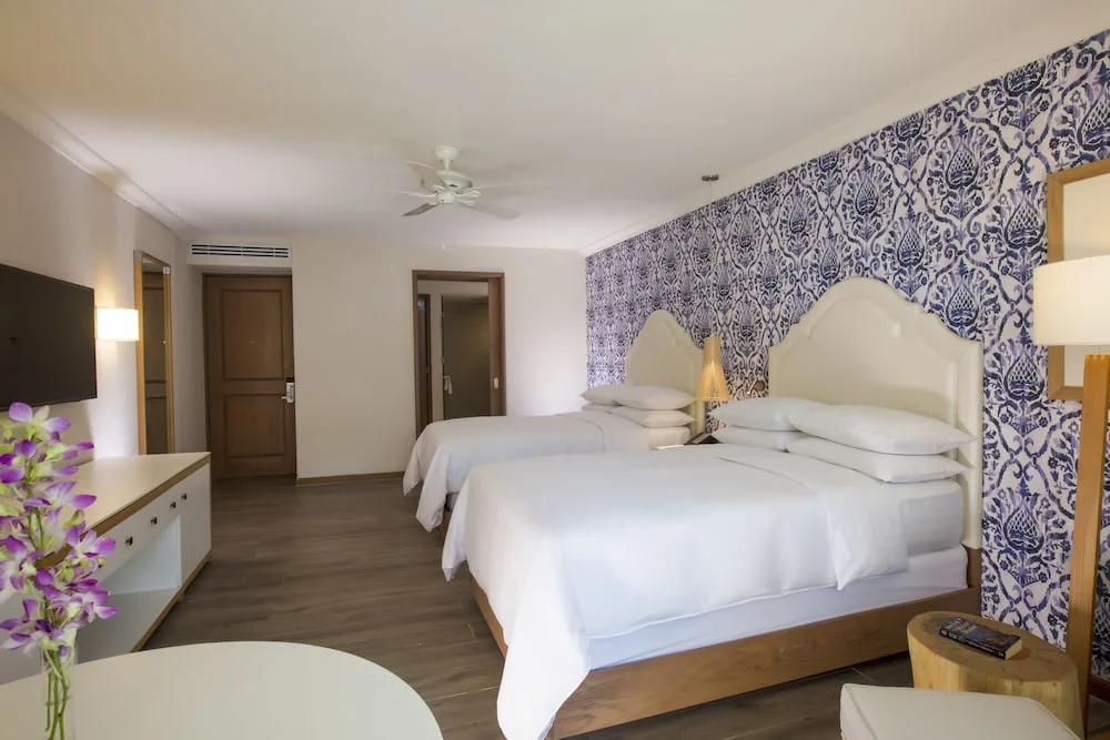 Two-bed guest room seen from the seating area at The Hacienda at Krystal Grand Puerto Vallarta.
