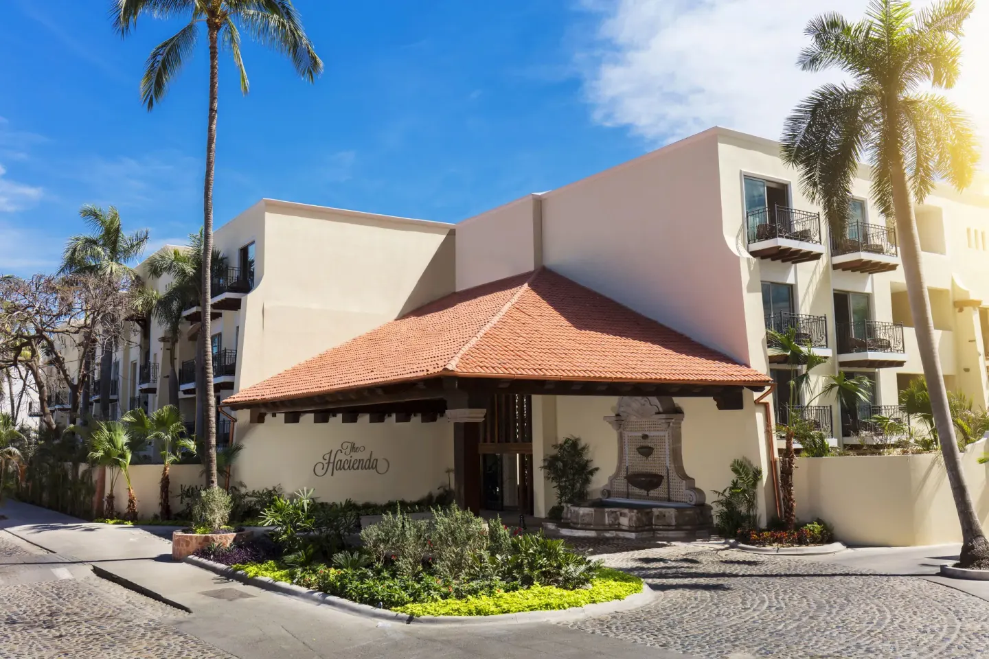 Resort entrance with tile roof and fountain at The Hacienda at Krystal Grand Puerto Vallarta.