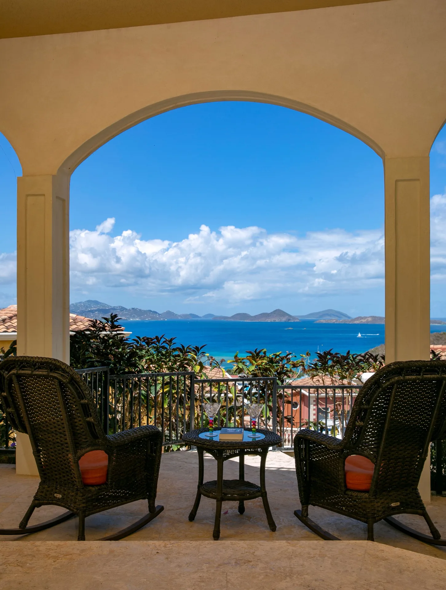 Arched terrace with rocking chairs framing the sea at The Hills, St John.
