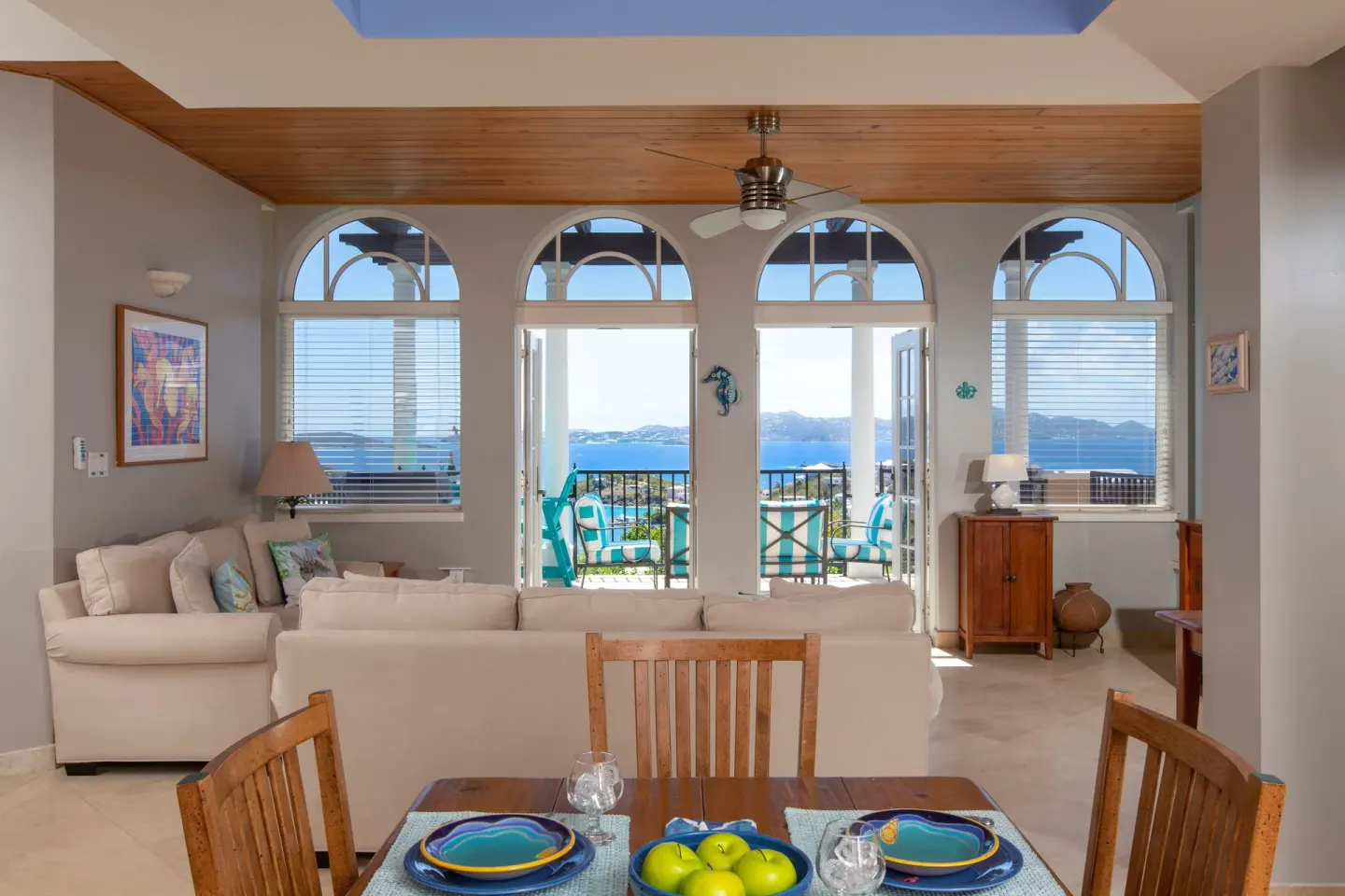 Dining and living area with arched windows and sea view at The Hills, St John.